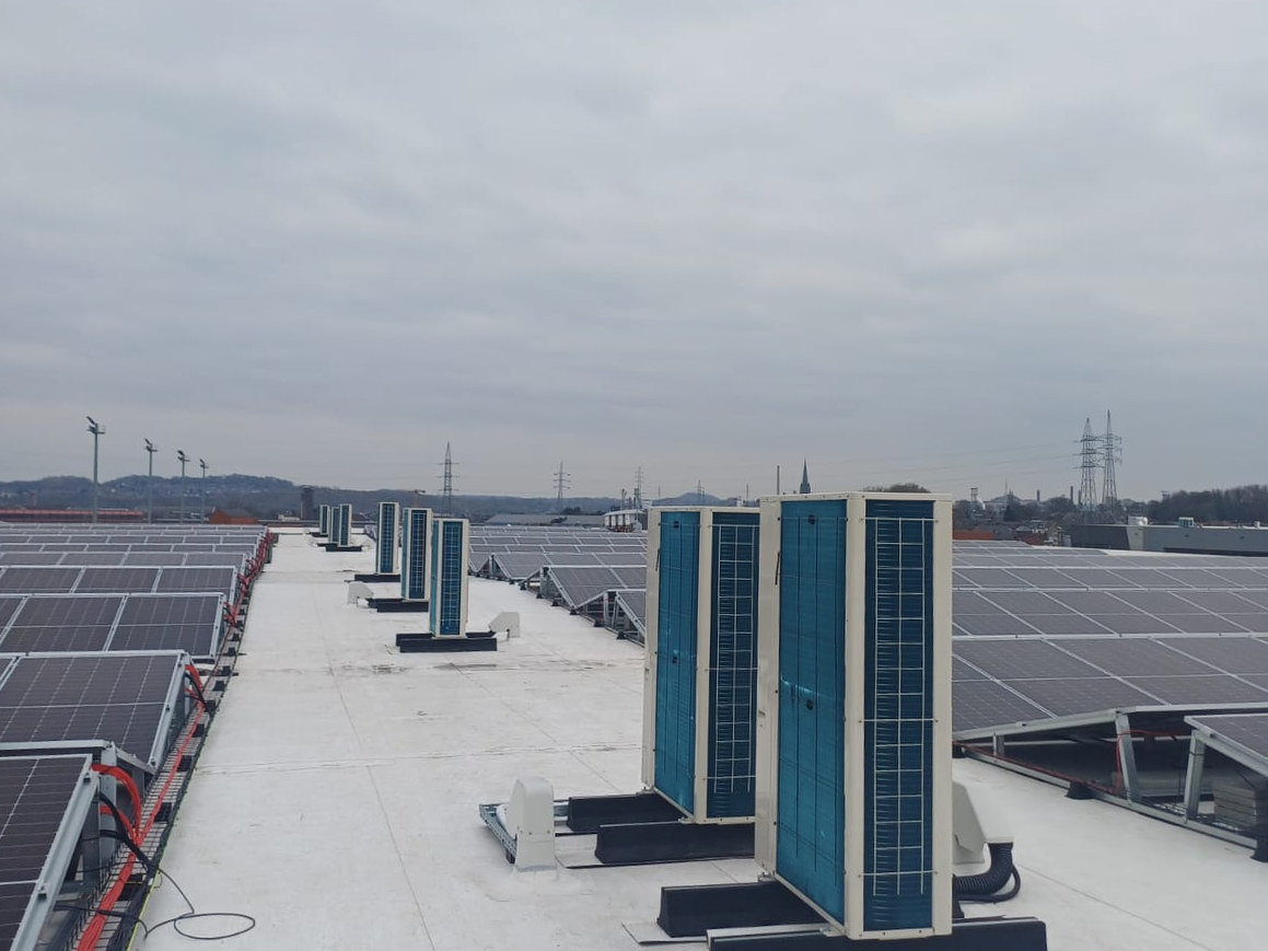 Rij buitenunits op een dak met zonnepanelen