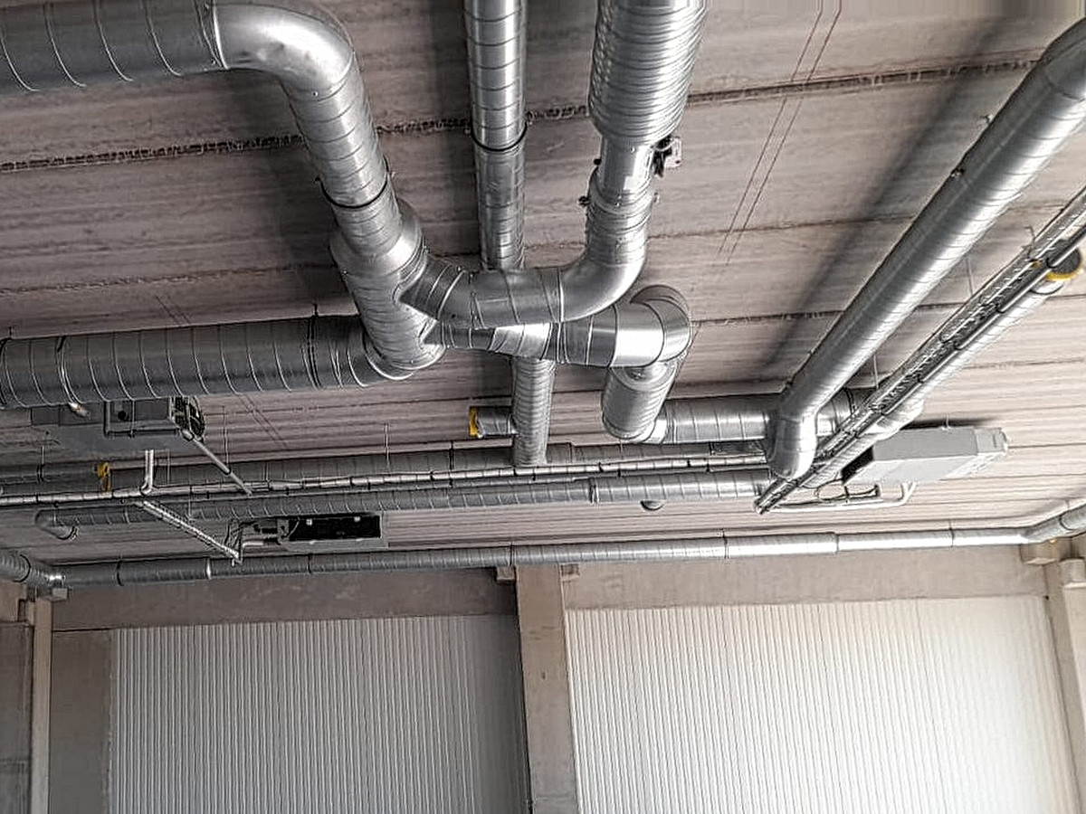 Kanaalwerk en klimatisatie-units onder een betonnen plafond